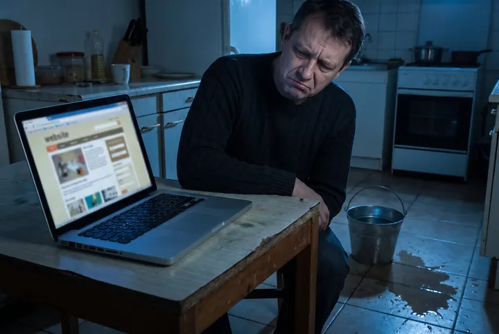 A worried homeowner frowning at an outdated plumbing website